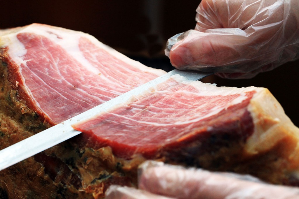 36364852 - traditional spanish ham on black close up. slicing hamon iberico